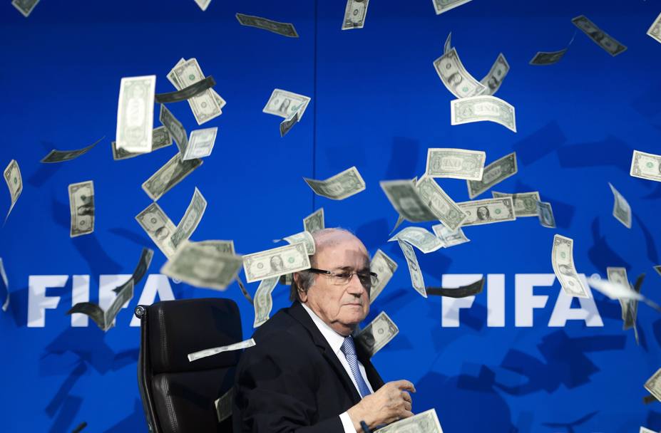 20 luglio 2015: il presidente della Fifa Sepp Blatter contestato con una pioggia di falsi dollari dopo la diffusione delle notizie sullo scandalo tangenti nel calcio (Afp)